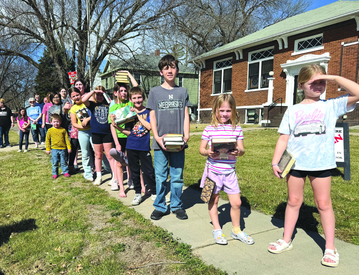 Above: Kids lined up to pass books just like 25 years ago. They ended up just running them. PCN photo by Rick Holtz. 