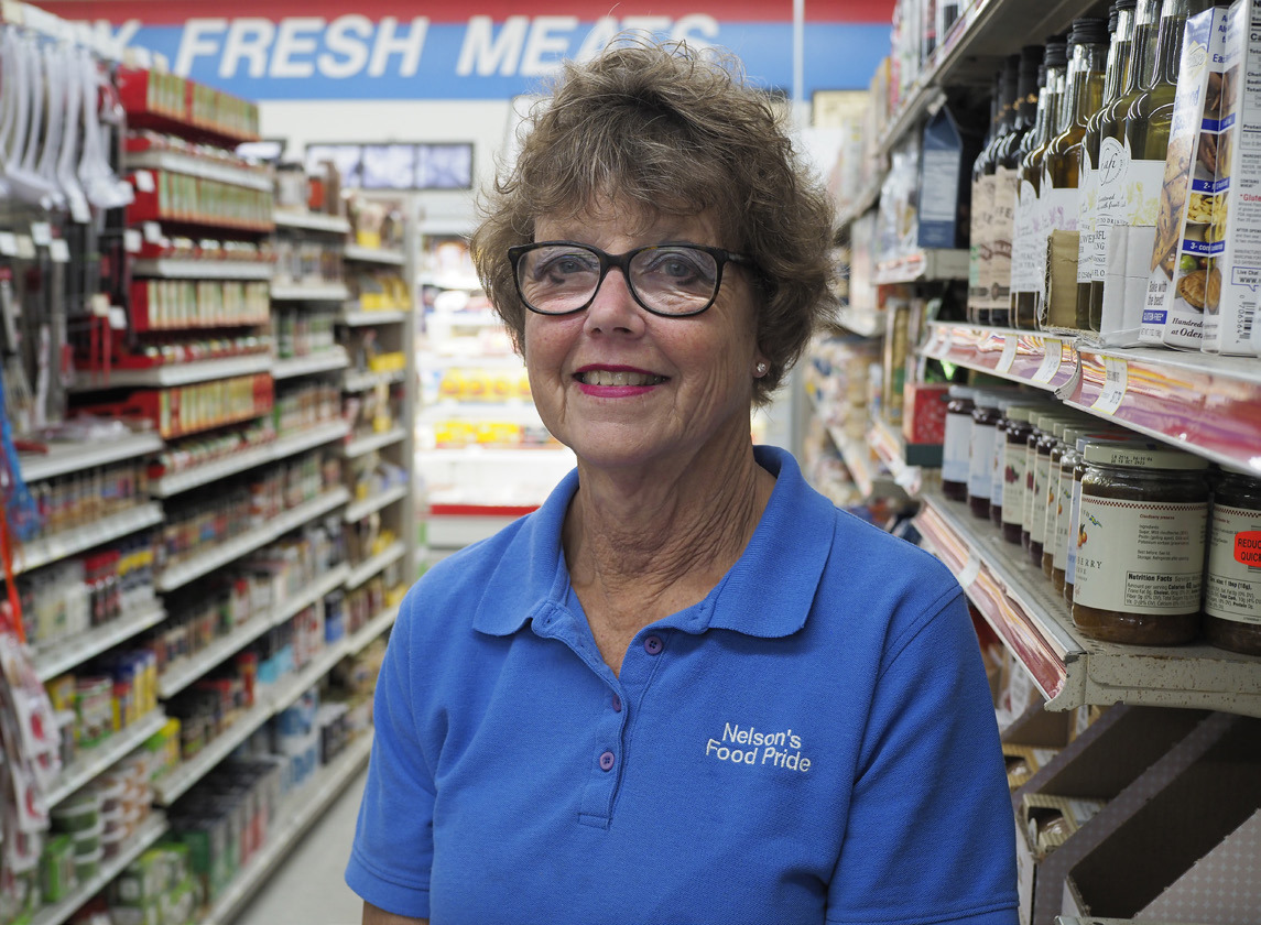 Above: Nelson’s Food Pride grocery store owner Julie Johnson stands in the aisle with Swedish goods at her family’s grocery store in Oakland. She tries to know the name of every customer who enters. “That’s small-town business,” she said. “Somebody has a birth and we hug them, and they have a death and we hug them.” Photo by Jerry L Mennenga for the Flatwater Free Press