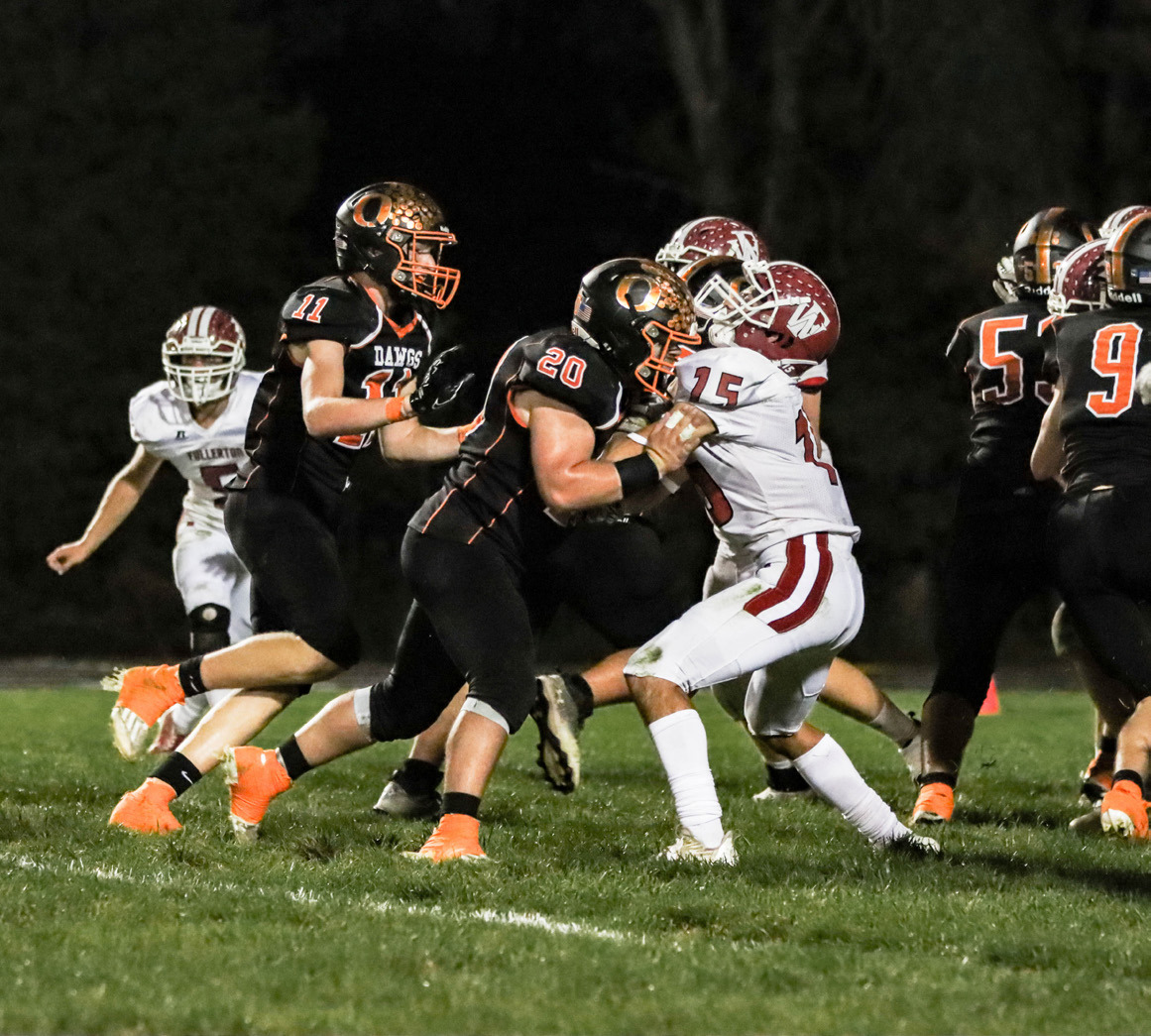 Conner Schnell (#20) blocks for the runner against Fullerton. PCN photo by Blaine Winslow.