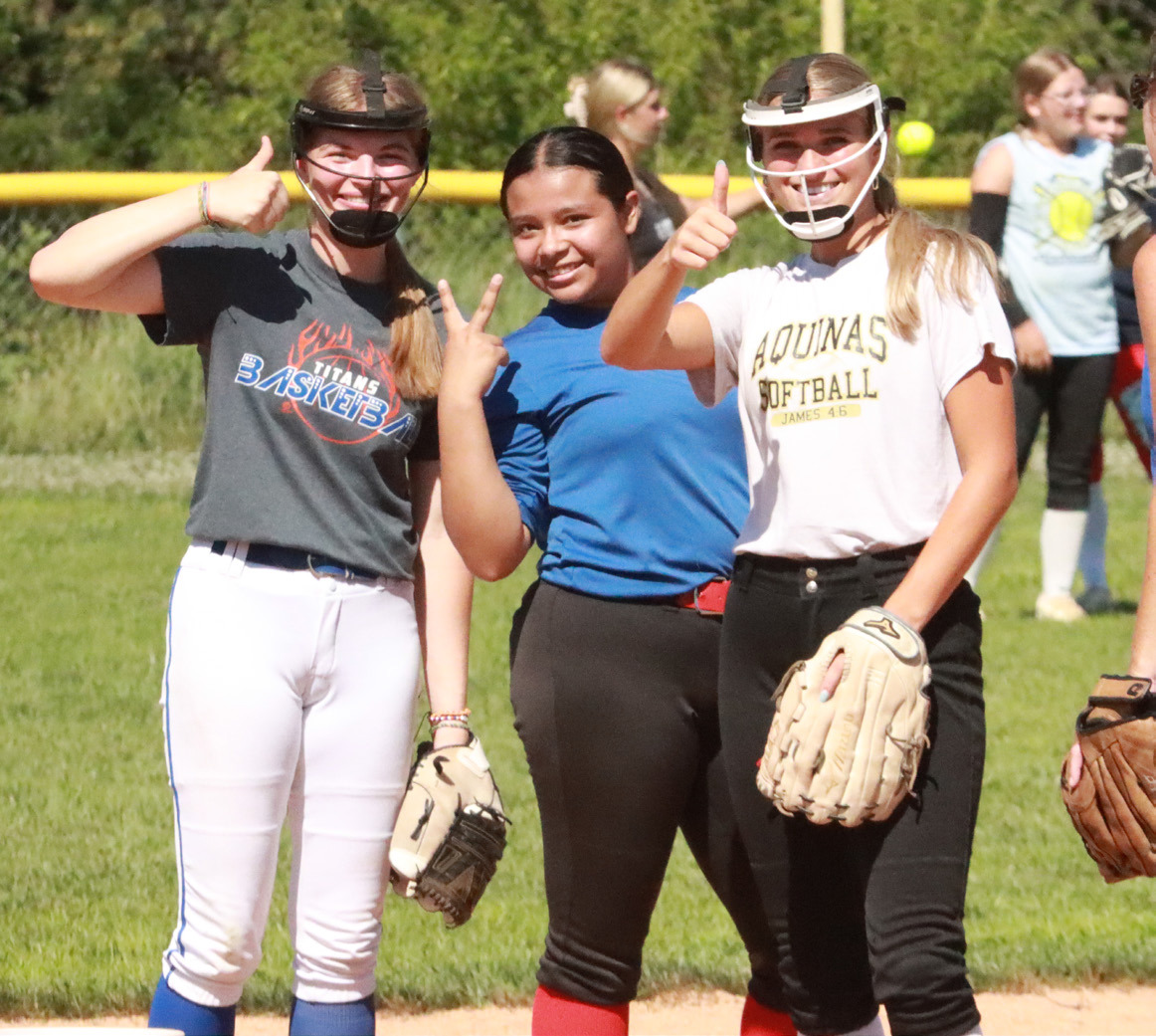 As well as softball fundamentals, Jadelynn Gifford, Jazlyn Ramirez-Catalan and Jordyn Vandenburg (Aquinas) work on their media skills. PCN photo by Ken Kush.