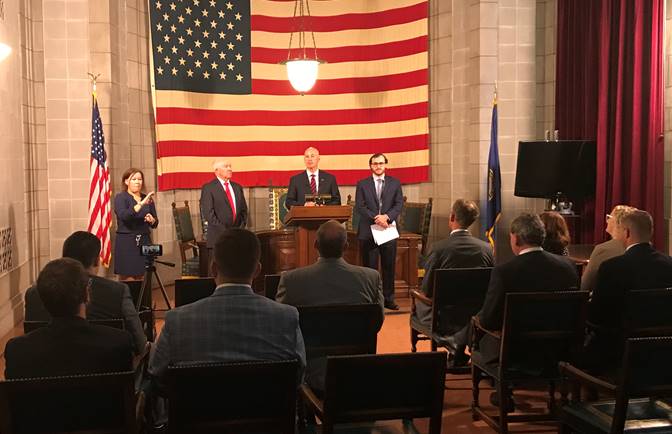 ASL Interpreter Kelly Brakenhoff; Dan Watermeier, Chair of the Nebraska Public Service Commission;  Gov. Ricketts (podium); and Patrick Redmond, State Broadband Coordinator