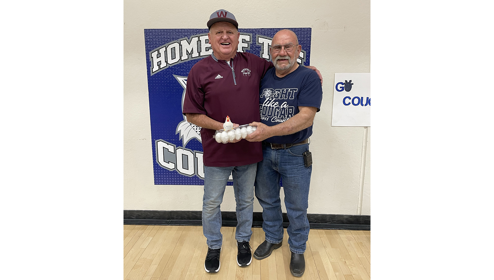 Stromsburg Mayor Ken Everingham collects his winnings from Wakefield Mayor Paul Eaton after Cross County's volleyball team defeated Wakefield to advance to state. PCN photo by Rick Holtz
