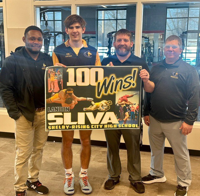 Landon Sliva (senior at Shelby-Rising City) recently got his 100th win in wrestling. He is pictured (second from left) with his coaches. Photo provided.