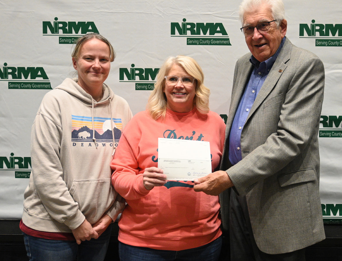 NIRMA Board of Directors member Larry Cerny (right), presents a dividend check to Polk County officials, Deputy Assessor Kris Udey (left) and Assessor Jodi Krance, at the program’s annual membership meeting in Kearney on October 24. Photo provided.