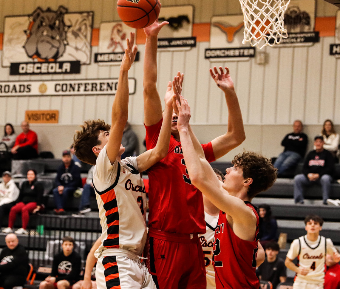 Osceola sophomore Landan Drozd (3) mixes it up with a couple of David City players as he battles for the rebound. PCN photo by Blaine Winslow.