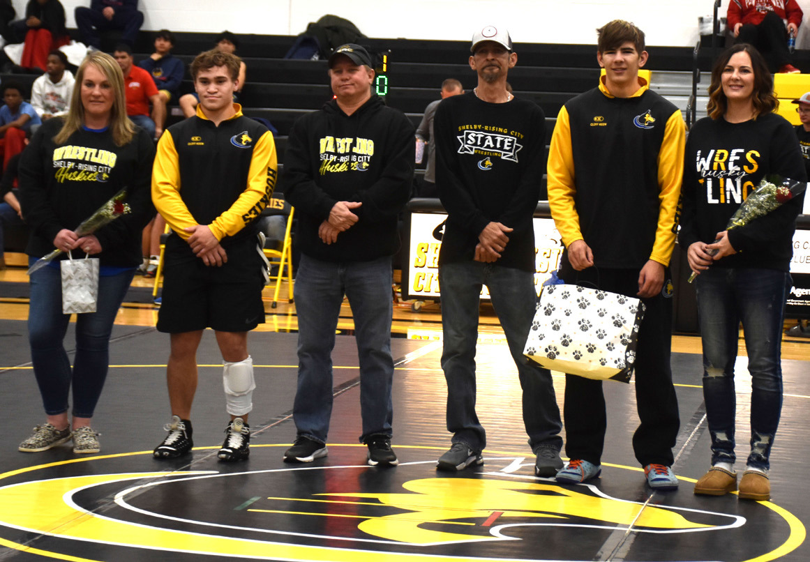 Shelby-Rising City seniors Ethan Fjell (second from left) and Landon Sliva (second from right) were recognized with their parents at the beginning of the Shelby-Rising City wrestling tournament. PCN photo by Beth Sparrow.