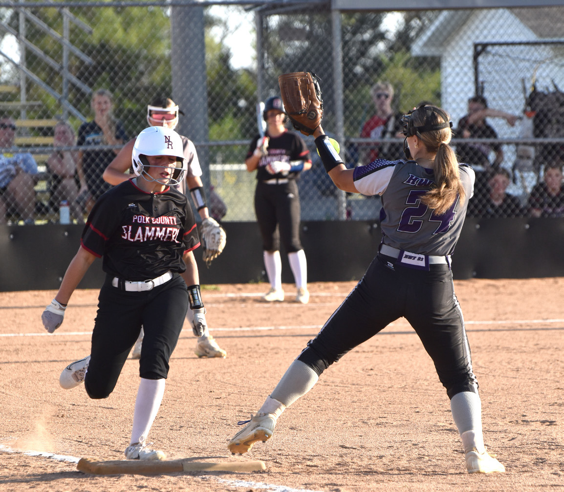 Polk County Slammers freshman Chloe Schott beats the throw to first base as the HWY 91 first baseman bobbles the throw. Schott went 3 for 4 with three RBI in her varsity debut. PCN photo by Beth Sparrow.