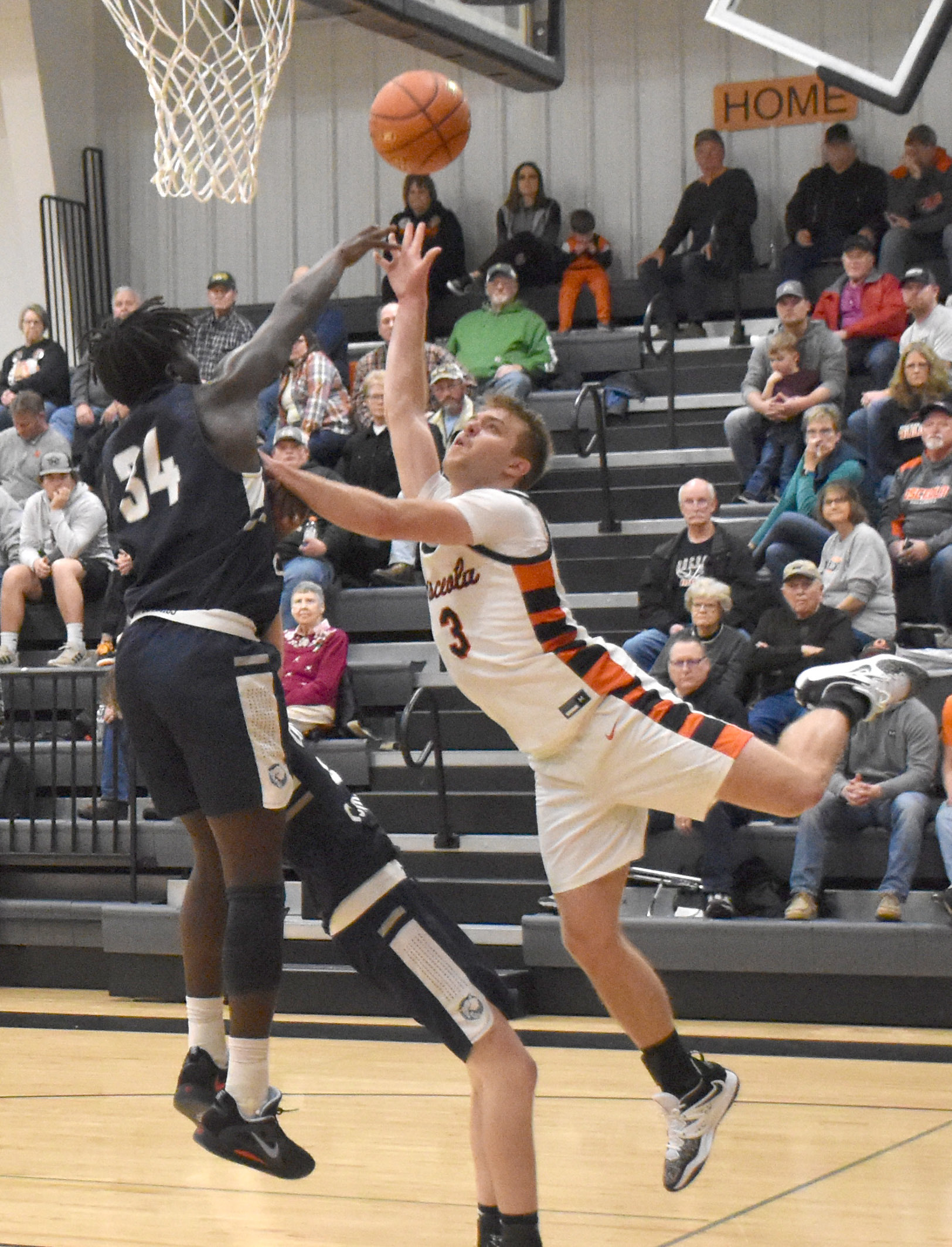 Osceola's Isaiah Zelasney uses acrobatic moves to get to the basket despite strong defense from Cross County's James Elgin. PCN photo by Beth Sparrow