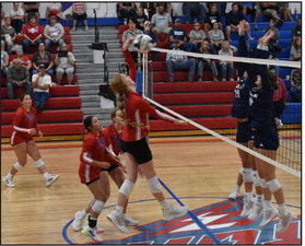 Peyton Hofmann goes up for a kill against Cross County’s block with her teammates’ support. PCN photo by Beth Sparrow.