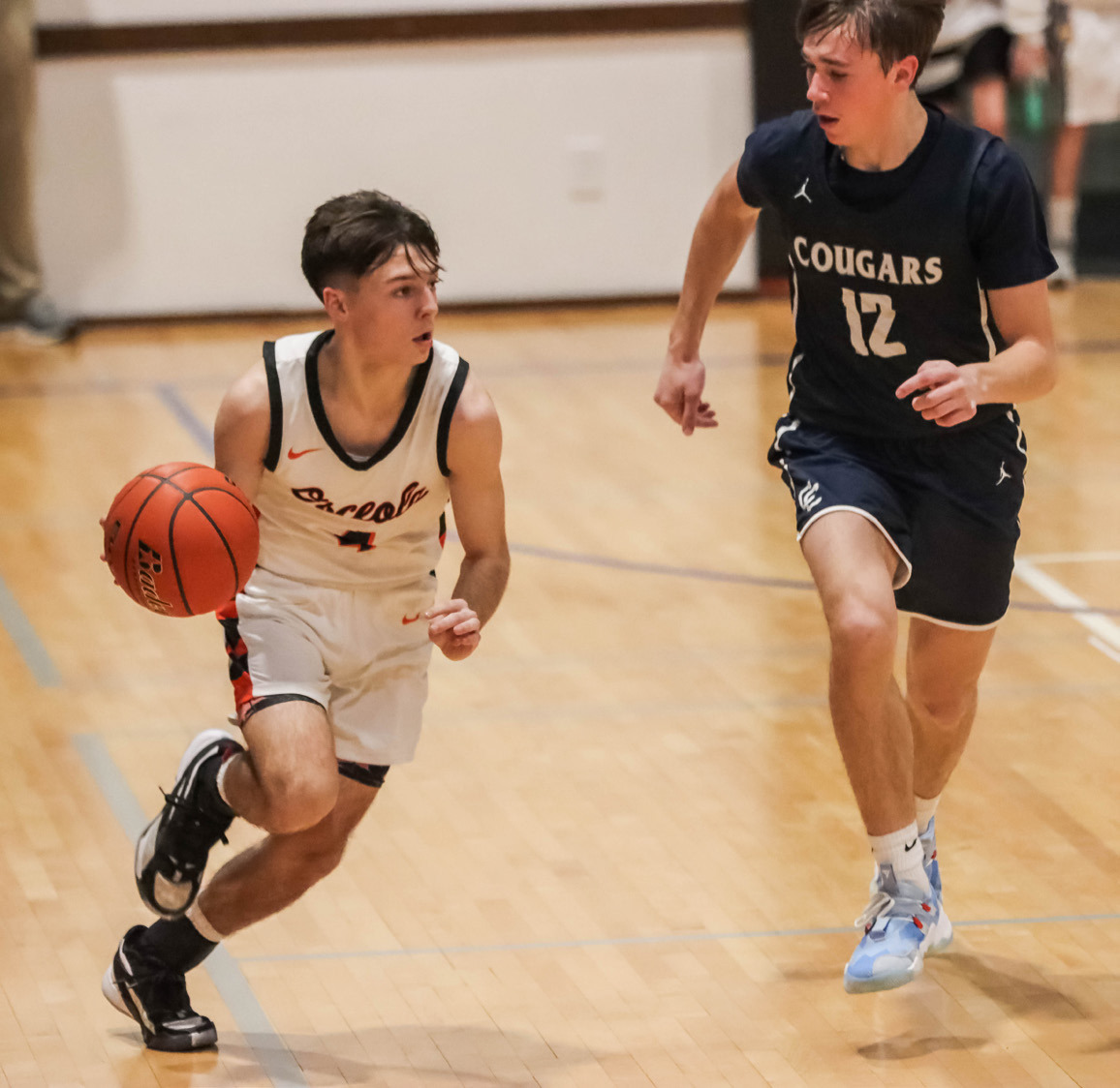 Brayden Santos (left, Osceola) tries to beat Thatcher Hanson (right, Cross County) down the court. PCN photo by Blaine Winslow.
