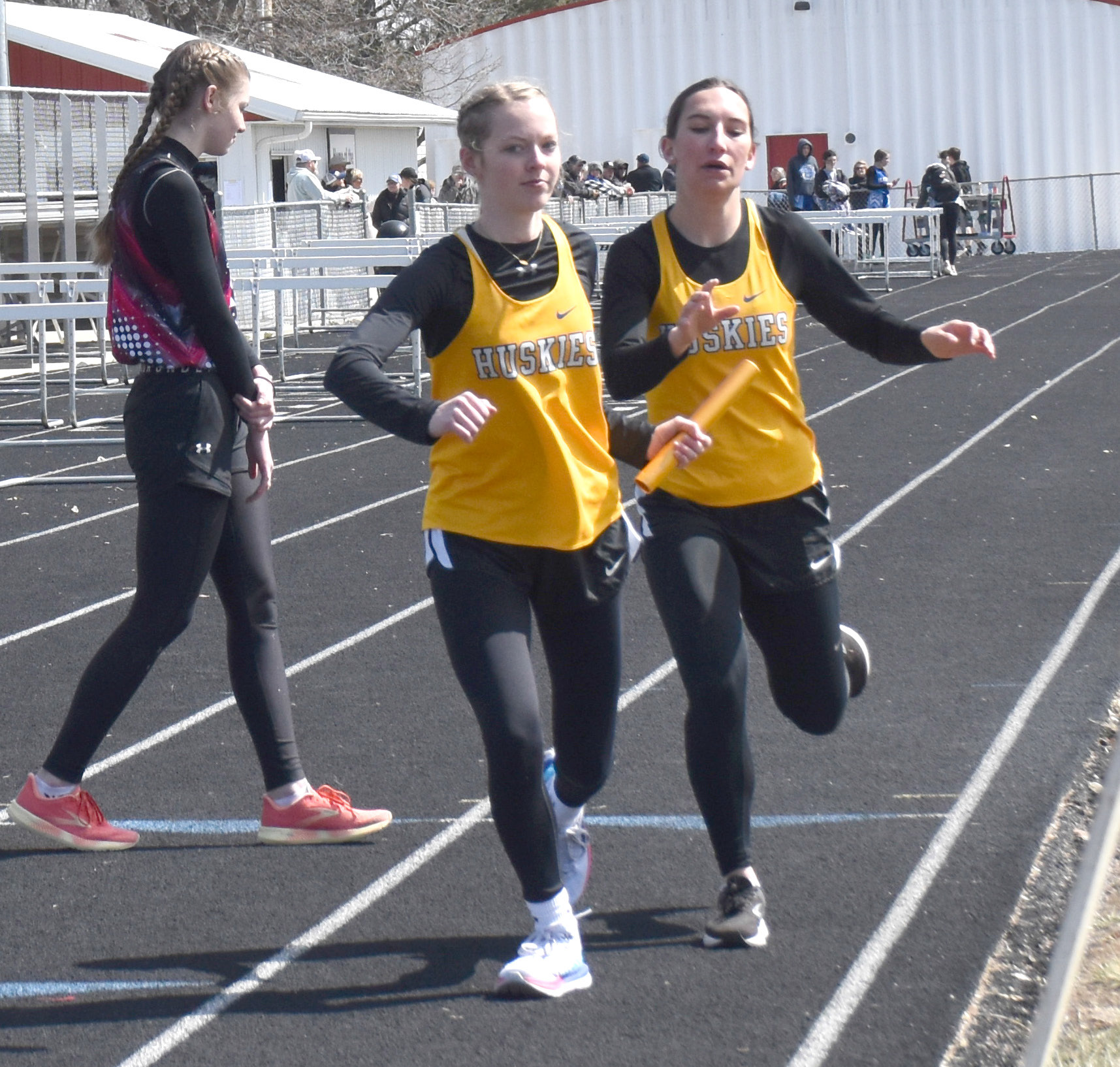 Ellie Frederick takes the handoff from Angel Barnes in the 4x800-meter relay. PCN photos by Beth Sparrow