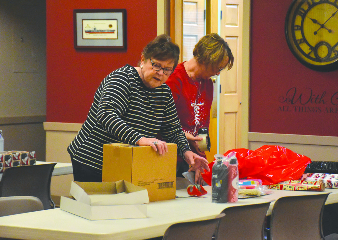 Above: The Giving Tree was successful again this year. Here volunteers wrap gifts for needy students. Pictured are Cheryl Sisty and Jodi Alvis wrapping. PCN photo by Beth Sparrow.