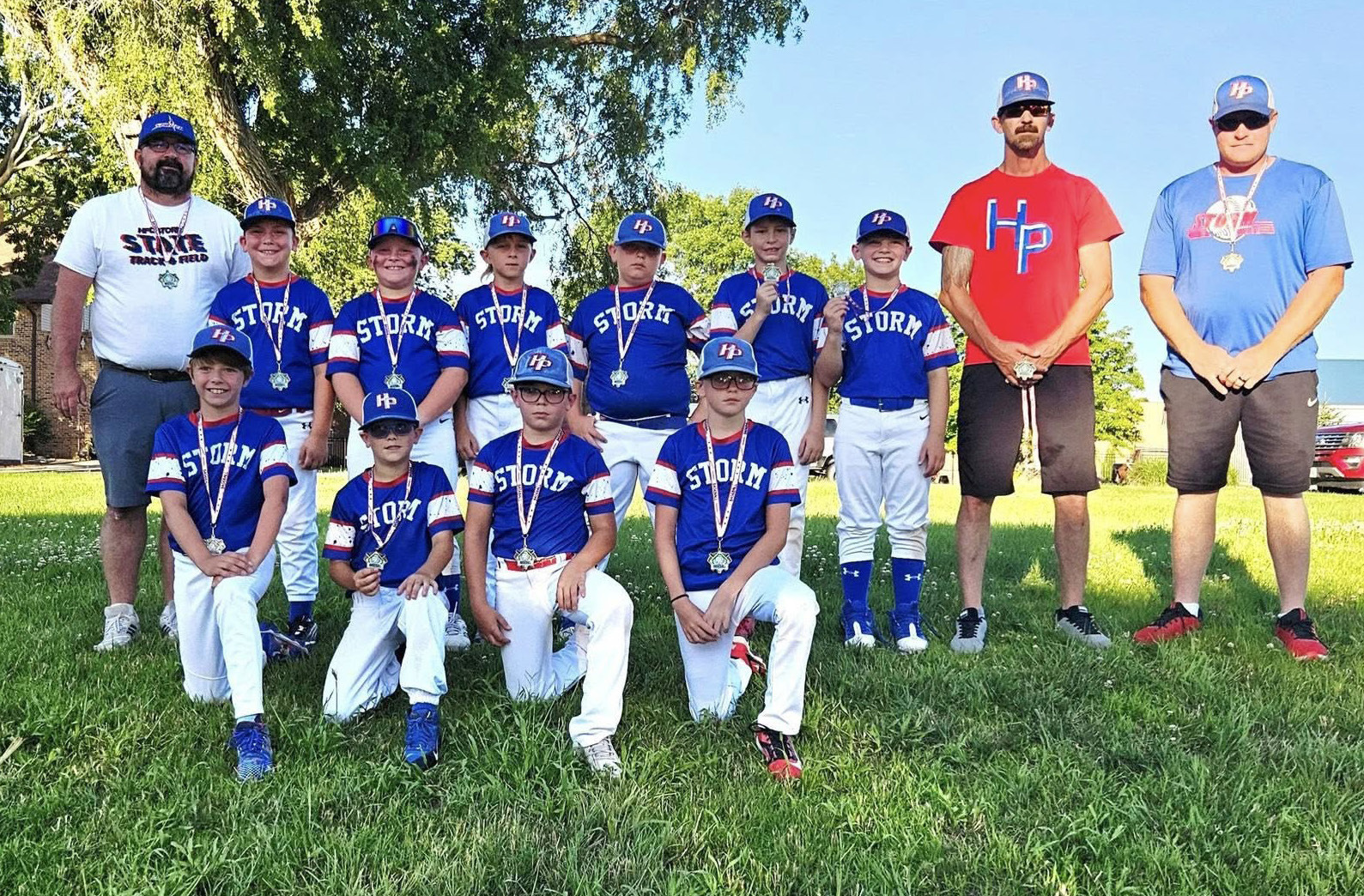 Above- The High Plains Storm 10-U Baseball team and coaches proudly displays their medals as they finished fourth in a recent baseball tournament. Photo provided.