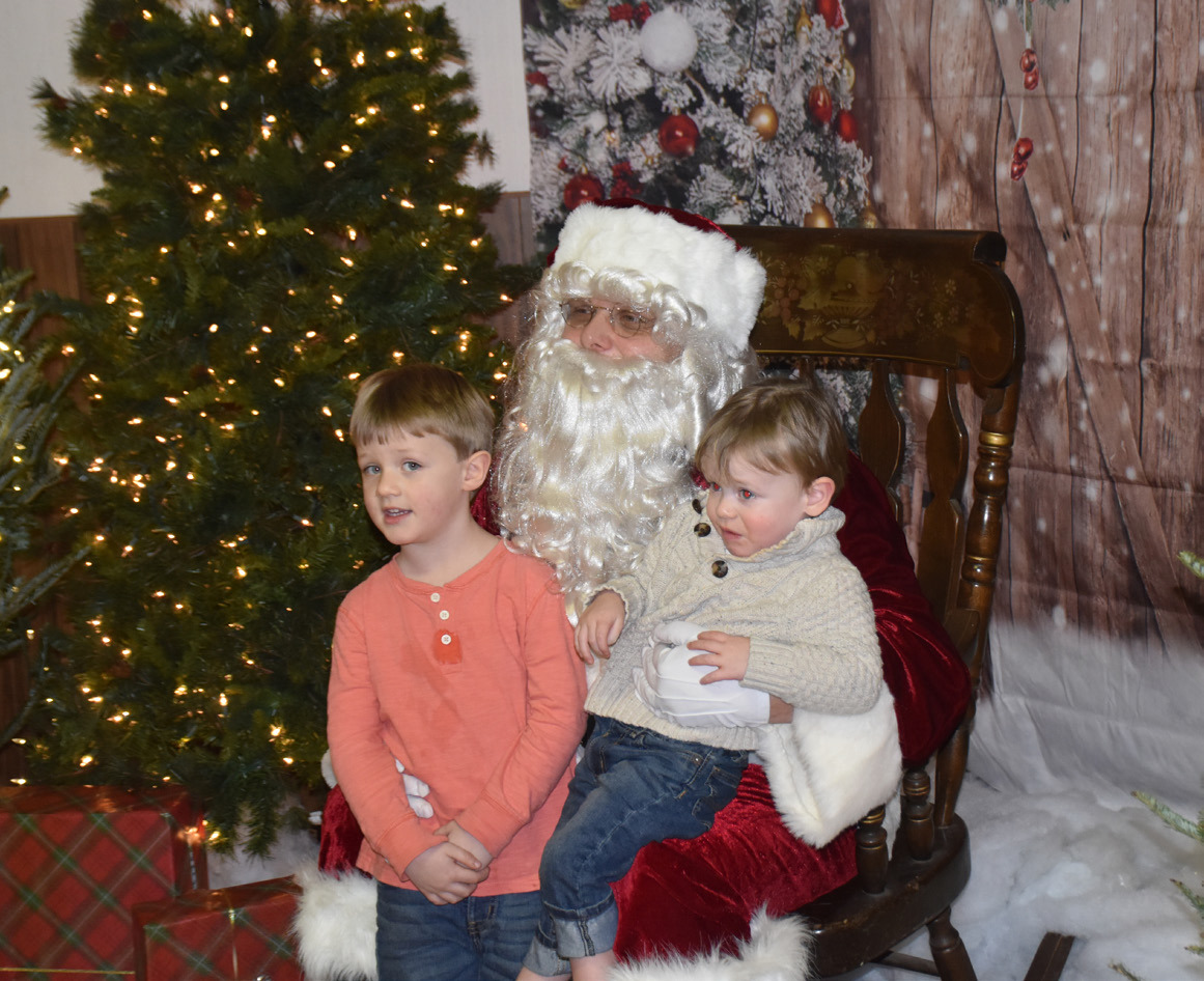 Above: Kids tell Santa their Christmas wishes at the Polk Community Building during the Christmas on Main event Sunday, December 3rd. Below: Some of the kids were afraid to sit with the Grinch, so Grandma volunteered. PCN photos by Beth Sparrow.