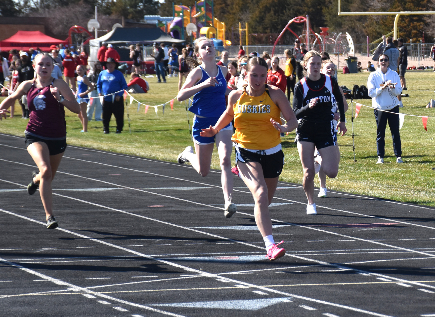 Kaylei Perry crosses the finish line first in the 100 meters. PCN photo by Beth Sparrow.