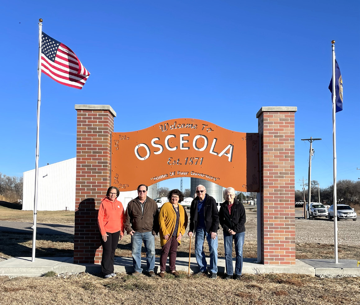 The Osceola sign now has flags. Pictured are Connie Boruch, John and Debbie Girard, and Norm and Marian Hofbauer. PCN photo by Lexi Reimers.