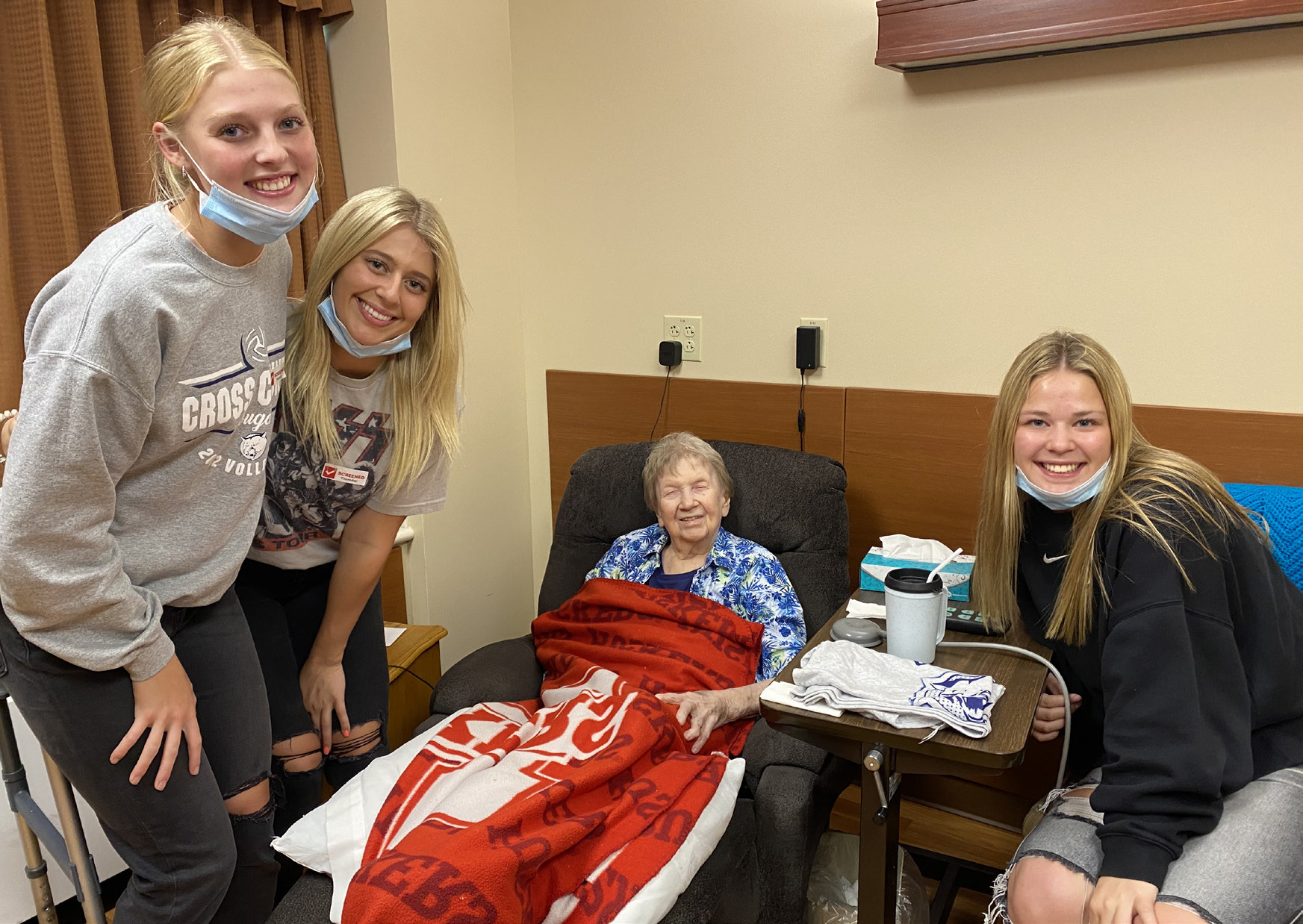 (left to right) Bren Lemburg, Taylor Lindburg (Annette's great-granddaughter), Annette and Jayden Fellows present Annette with a new Cross County T-Shirt that was donated by the Cross County Booster Club. Photo provided by Erin Dickey.