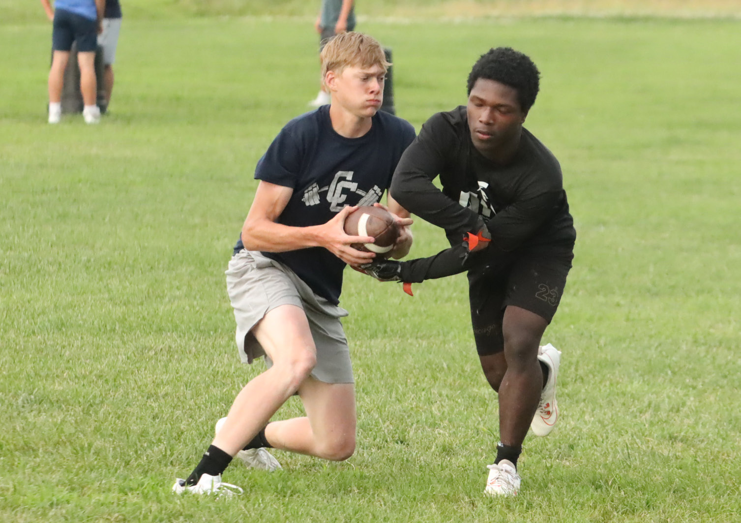 Cross County senior quarterback Sawyer Anderson pulls the ball back from running back Tyion Francis during the Cougars final summer practice. PCN photo by Ken Kush