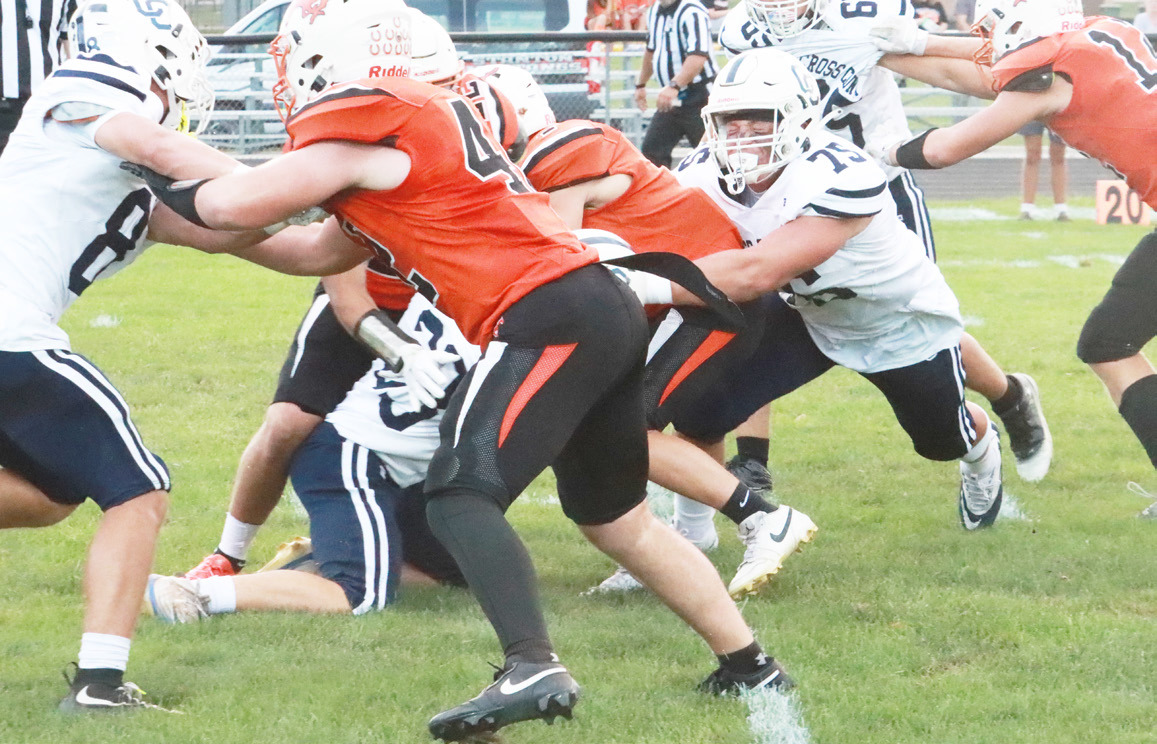 Top- Cross County senior Mason Quilhot (75) grabs the Stanton ball carrier 