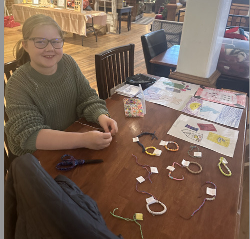 Above: Olive Peterson sold handmade bracelets at 4th Street coffeehouse. Below: Maya Lonsdale and Macie Schmidtberger sold gnomes at Rose Colored Glass. All three girls are students at Cross County. Photo provided.