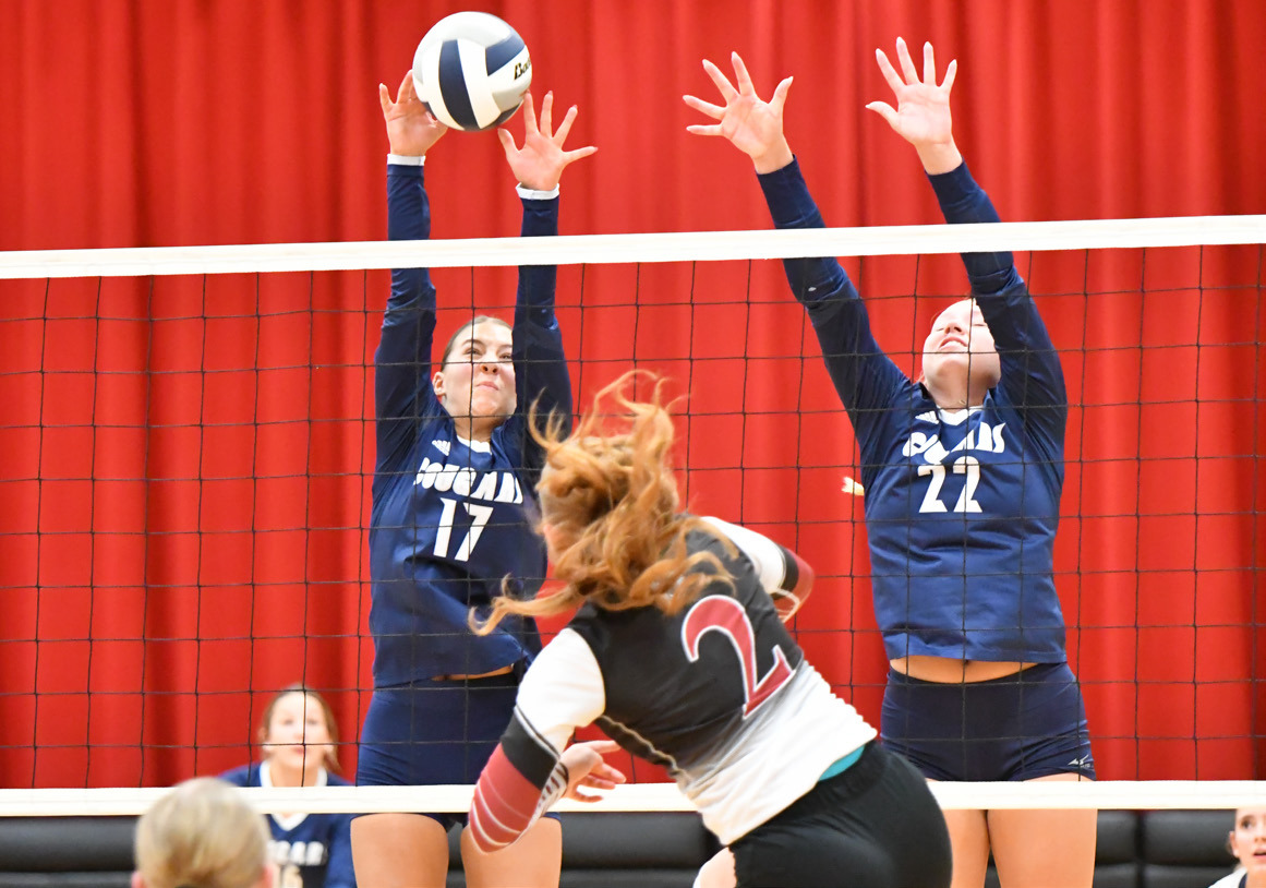 Top: Cross County sophomore Saphira Osentowski (17) and senior Sydney Hengelfelt (22) set up the block in last Thursday night’s game at Fullerton won in three sets by the Cougars. 