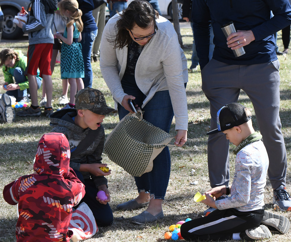 Families open their eggs on Saturday after the Stromsburg Easter Egg Hunt. PCN photo by Rick Holtz