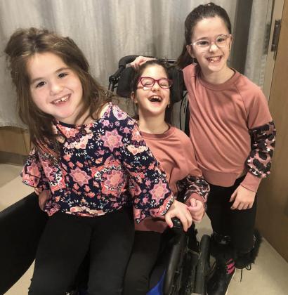 Maeleigh McConnell (center) is pictured with her sisters. Photo provided.