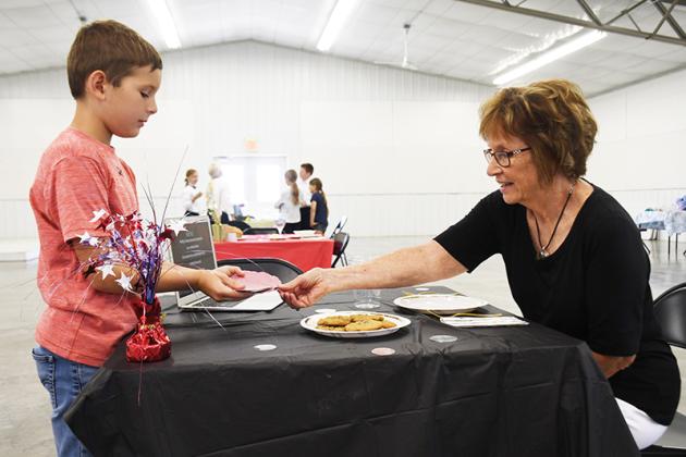 Talk about dinner and a show. Henry Cramer of Stromsburg performs a magic trick before serving his cookies Wednesday afternoon as part of the Culinary Challenge.Polk County News Photo by Rick Holtz