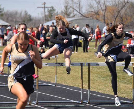 Above: Lucy Berggren leaps over the 100m hurdles. Below: Langdon Arbuck hands off to Jed Berggren in the 4x400m relay. PCN photos by Cienna Friesen.