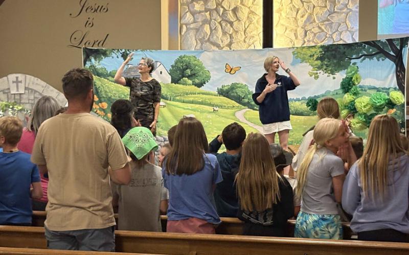 Vacation Bible School is going on now at Stromsburg Evangelical Free Church. Kids here are singing along with Summer Lukasiewicz and Lexi Eller (below) and answering what they learned (above). PCN photos by Beth Sparrow.