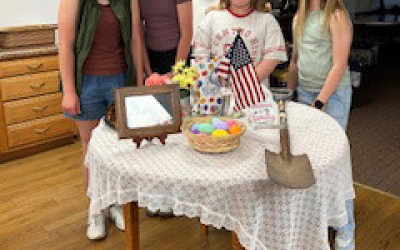 Left: Four girls helped set the military child’s table at a Legion Auxiliary meeting. Right: Poppy poster winners were 4th graders Zaara Moore and Scarlet Peterson. Posters were displayed at Economy Hometown Market. Photos provided.
