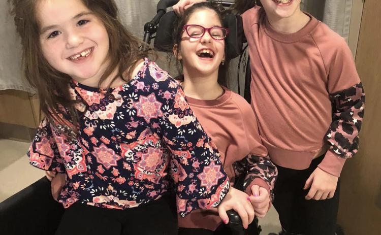 Maeleigh McConnell (center) is pictured with her sisters. Photo provided.