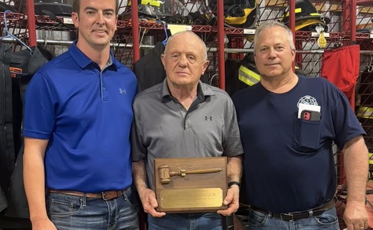 Gene Schlesinger was honored for 22 years as president of the department. Pictured are President Nate Kracl, Gene and Fire Chief Jon Eller. Photo provided.
