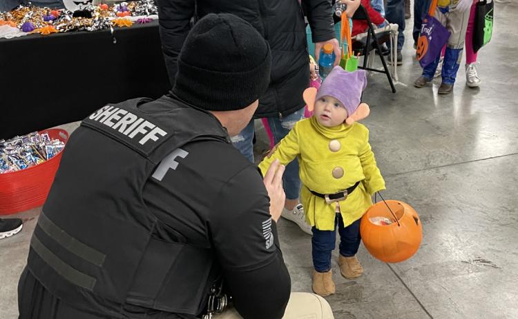 Deputy Sumsion, with the Polk County Sheriff, hands a Sheriff’s sticker to Dopey, one of the Seven Dwarfs. Dopey was Renli Hays, daughter of Makenzi and Eric Hays. Photo provided by Tasha Weller.