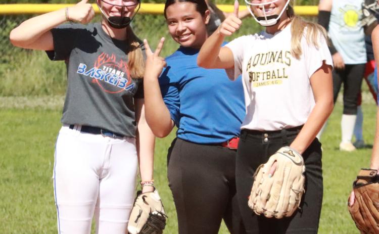 As well as softball fundamentals, Jadelynn Gifford, Jazlyn Ramirez-Catalan and Jordyn Vandenburg (Aquinas) work on their media skills. PCN photo by Ken Kush.
