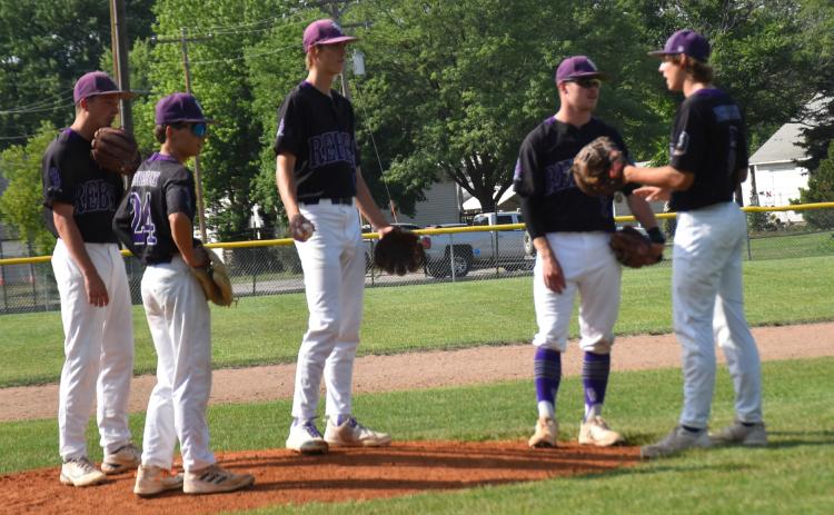 SOS players meet on the mound to strategize. PCN photo by Beth Sparrow.