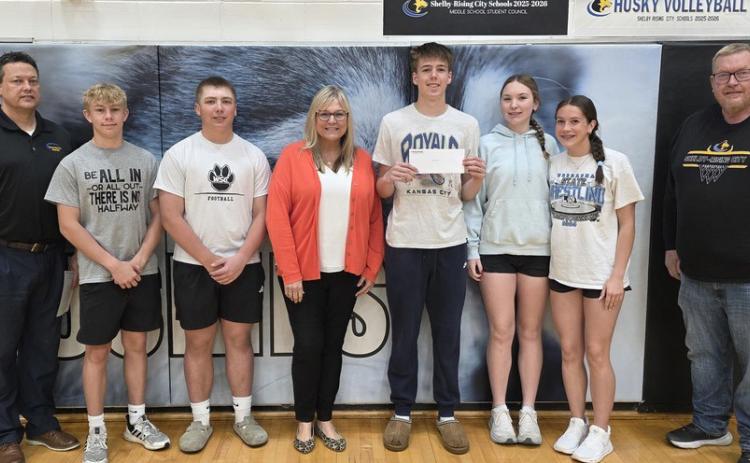 Pinnacle Bank donated money for every 3-pointer and every pin made in the winter sports season. Pictured above is Shelly Nekl (Pinnacle Bank) with basketball players and coaches Kravig and Connell. Below she is with wrestlers and Coach Kuhn. Photos provided.