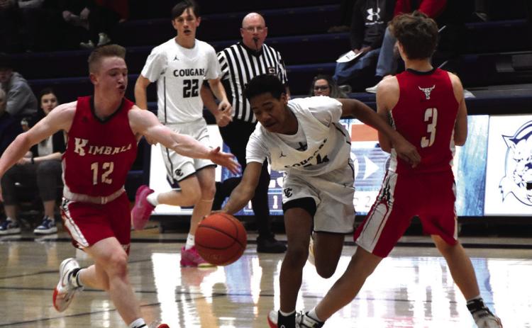 Benji Cooper dribbles between two Kimball defenders. The freshman had a couple timely plays for the Cougars. PCN photo by Beth Sparrow.