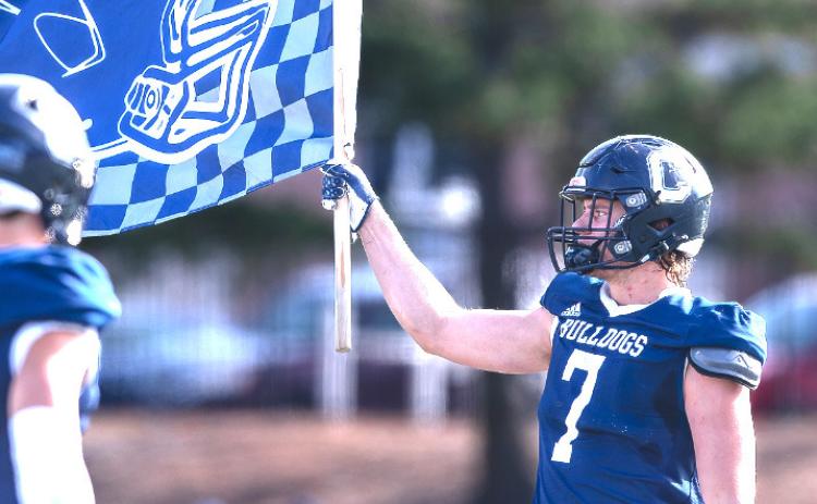 Kyle Sterup, Osceola graduate, carries the flag after a Concordia win. Photo provided.
