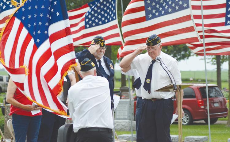 Stromsburg American Legion Commander Perry Noyd (right) salutes the American flag Monday morning at the Memorial Day Services at the Stromsburg Cemetery. Close to 200 people were on hand to honor and remember the fallen soldiers. Photo by Rick Holtz