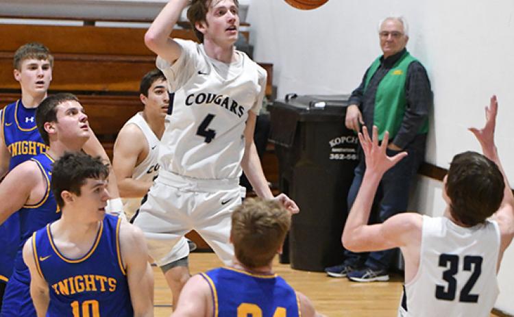 Levi Miller drives to the basket and passes the ball to a cutting Wyatt Hengelfelt, who is open underneath the basket. PCN photo by Rick Holtz
