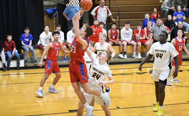 Carter Urkoski finishes at the basket and draws a foul on the Mustang defender in the third quarter on Tuesday. PCN photo by Rick Holtz