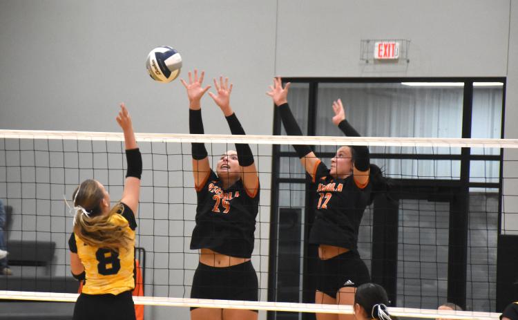 Hayden Hopwood (SRC) goes for a kill as Graci Conkling and Alexis Burritt (OSC) block. PCN photo by Beth Sparrow