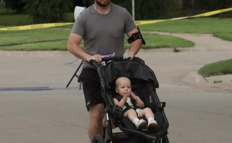 This runner brings his young one along as he starts his 10K run on Saturday. PCN photo by Ken Kush