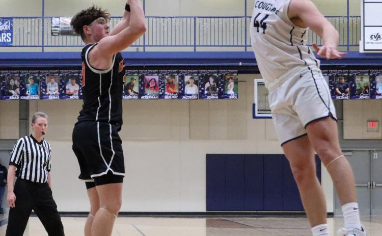 Senior Kale Gustafson (OSC) takes the shot over senior Tanner Hollinger (CC) on Tuesday.