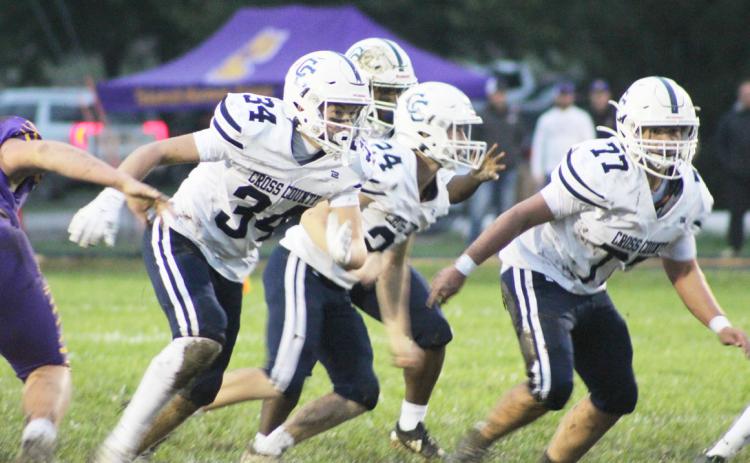 The Cross County Cougars front line of Benson Seim (34), Bode Berggren (24) and Krayton Schoch (77) provide blocking for the Cougars back at Tekemah Herman on Friday night. PCN photo by Trevor Blevins.