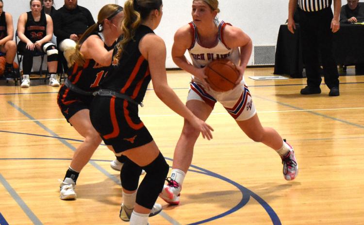 Courtney Carlstrom faces two Dorchester defenders in the conference game Friday afternoon. PCN photo by Cienna Friesen.