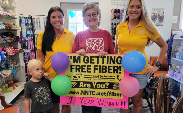 Above: Clare Quandt of Stromsburg won a free year of fiber internet and TV service from NNTC (Northeast Nebraska Telephone Company). She is pictured (center) with grandson Hans (left) and NNTC representatives. PCN Photo by Beth Sparrow.