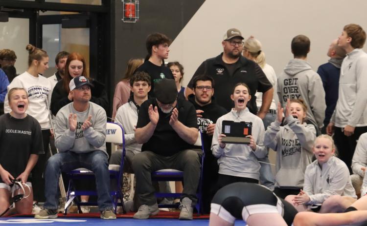 The Cross County/Osceola girls wrestling coaches, team members and some of the boys wrestling team look as history is made when freshman Piyper Berggren scored the first win in the history of the Twisters program. PCN photo by Ken Kush.