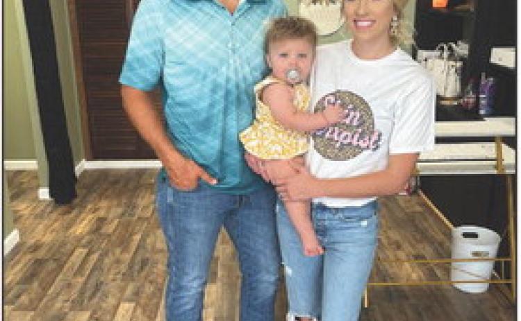 Emily Pogue has started Beauty on Demand Esthetics in Stromsburg. Pictured is Emily with her fiance and daughter in the building they renovated. Photo provided.